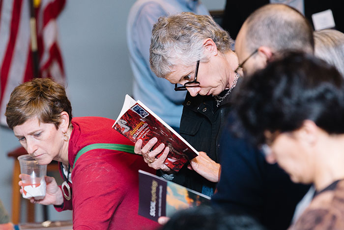 Participants skim through faculty books on display at a table