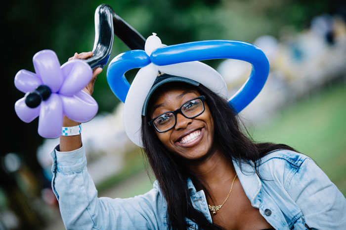 An Emory alum poses in a balloon hat at the Homecoming Festival