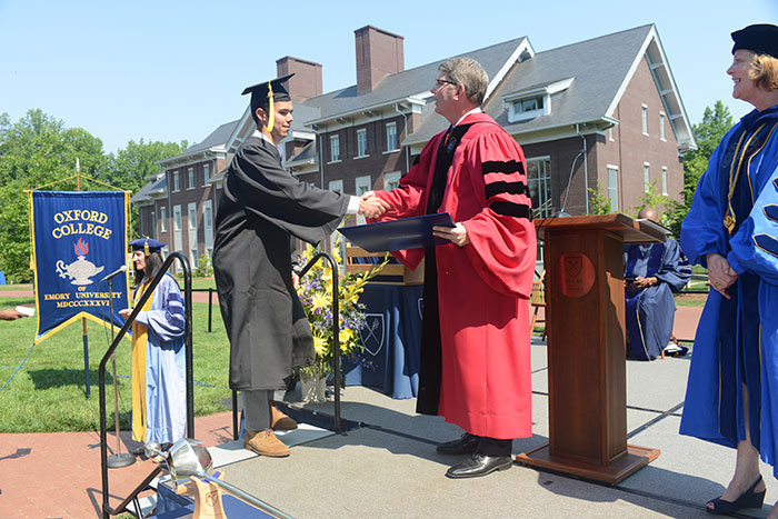 Oxford College Dean Hicks shakes hands with a graduate 