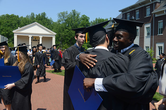 Two graduates exchange a hug after the ceremony