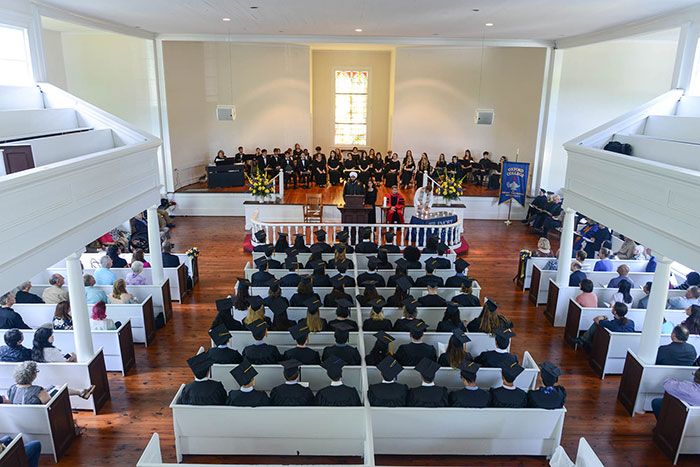 A birds-eye view of the chapel shows a full house of students, faculty, and family members and friends