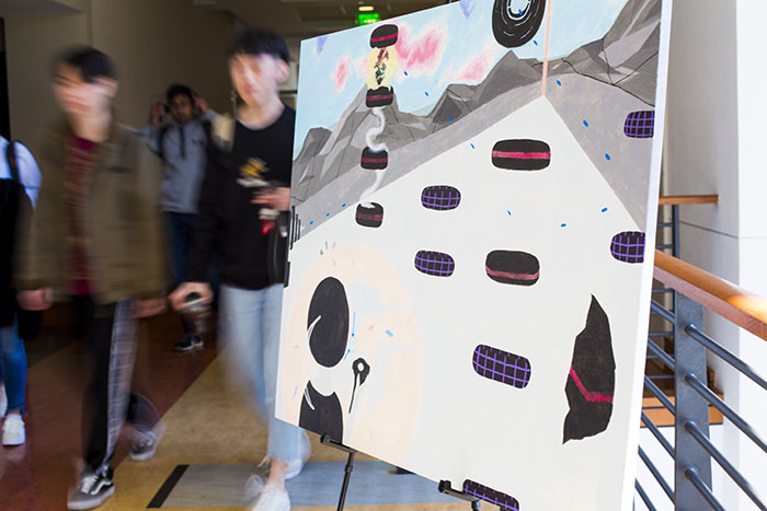 A painting by Georgia Tech student Bianca Guerrero portrays a virtual reality game used to measure players¿ perception of time as well as eye movement. Students walk by the display at the Atlanta Science Festival.