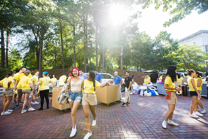 Several students gather to help each other move in