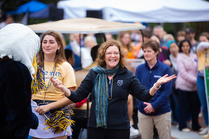 Emory President Claire E. Sterk holds her hands up excitedly