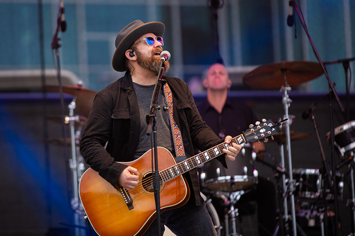 Kristian Bush sings and plays guitar on a stage