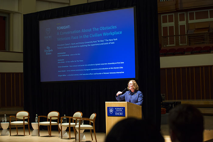 Emory President Claire E. Sterk speaks at a podium on a stage
