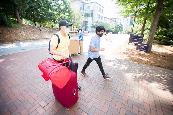 Two students move belongings on campus