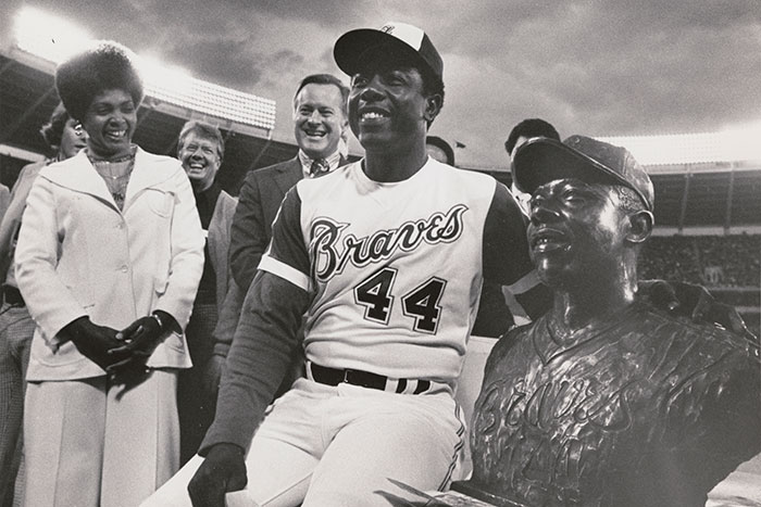 Hank Aaron is shown sitting with his bust