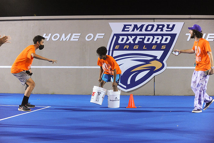 Students in orange t-shirts compete in the Oxford Olympics