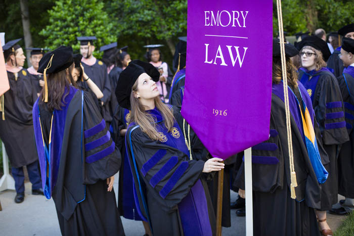 A law school student looks up at the Emory Law gonfalon.