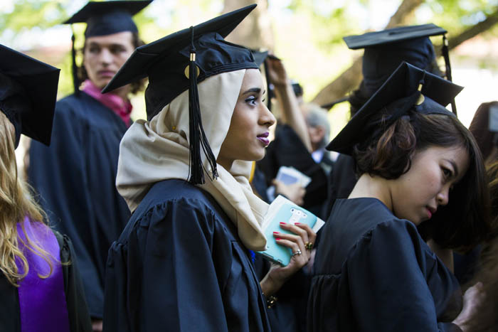 A female graduate listens to the commencement address