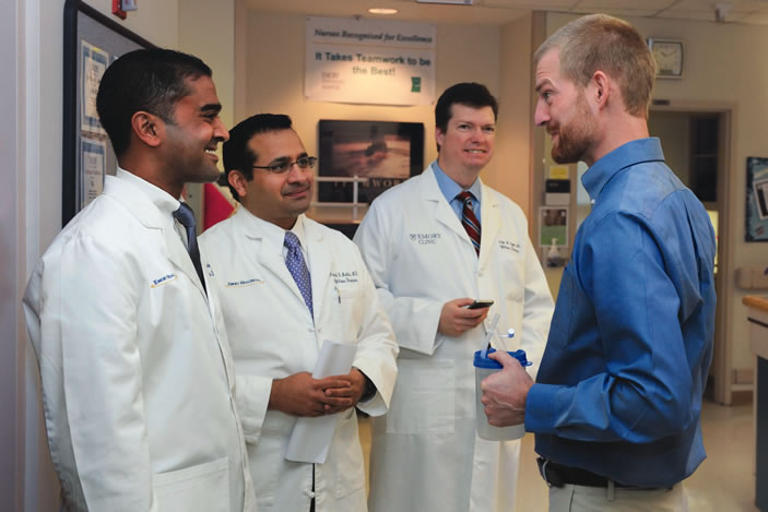Infectious disease physicians Jay Varkey, Aneesh Mehta, and Marshall Lyon talk with Kent Brantly, the first patient with Ebola to be treated in the US, on the day of his release from Emory Hospital's isolation unit.