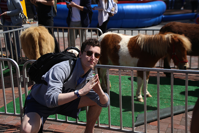 man posing in front of miniature pony