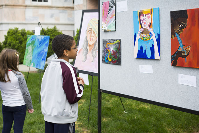 A young boy looks at art on display