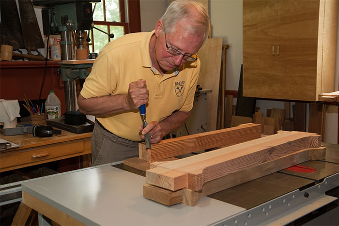 The woodshop is in the north wing of the President's House.  Here Dean Bowen uses a wood chisel to finish one of the table legs.