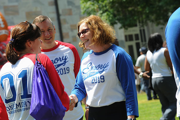 Emory President Claire E. Sterk shakes hands with staff