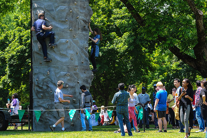 Emory staff members climb a rock wall