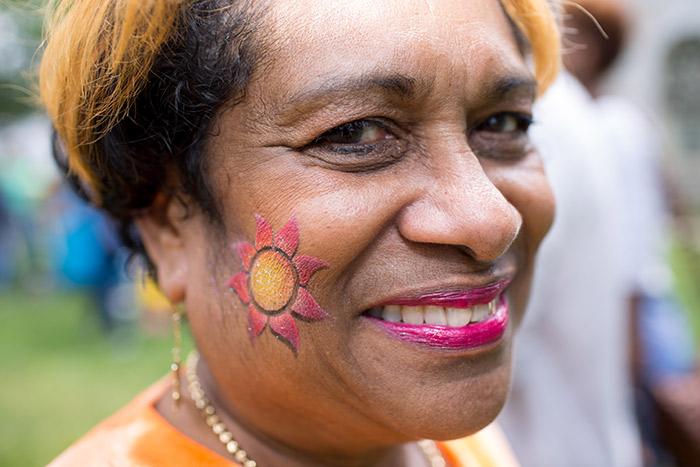 A staff member poses with a temporary tattoo on her cheek