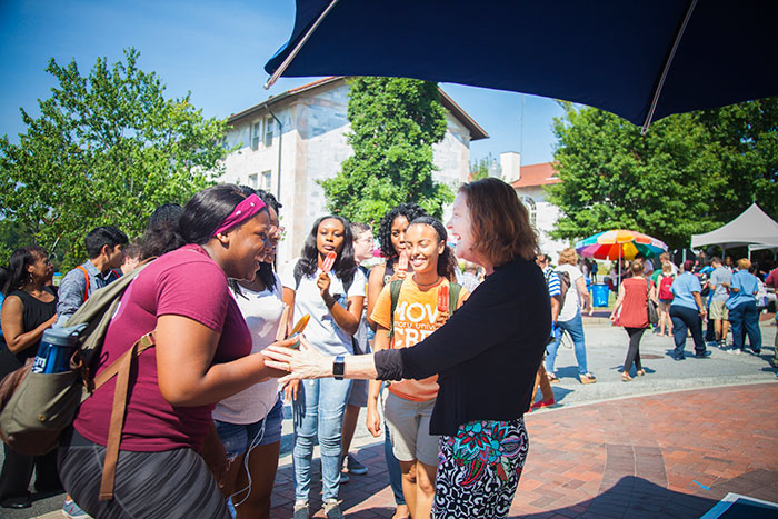 Emory President Claire E. Sterk greets attendees at the welcome block party.