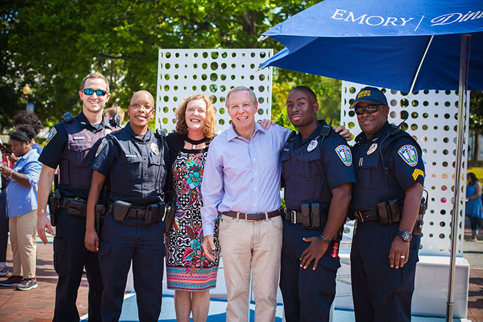 President Claire E. Sterk and her husband, Kirk Elifson, pose with Emory Police Department officers.
