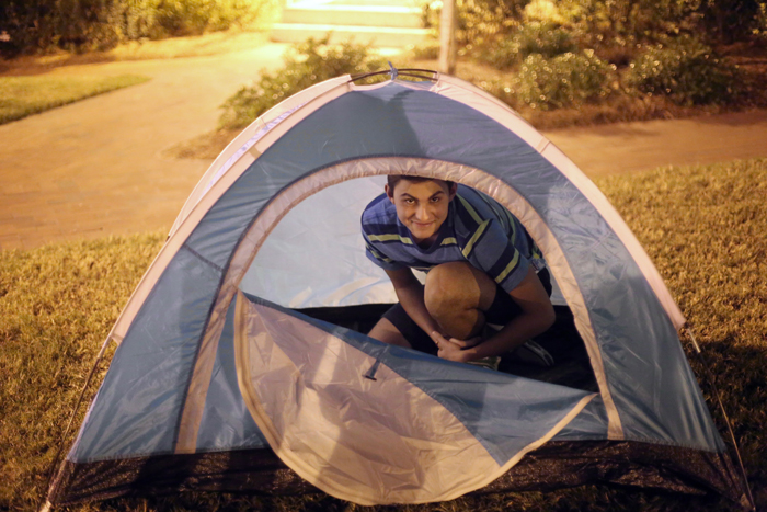 Male student in small camping tent at Camp Swoop.