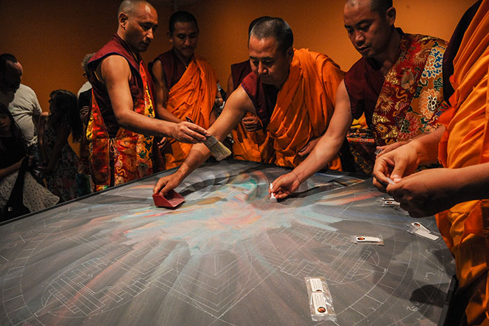 mandala sand being scooped up