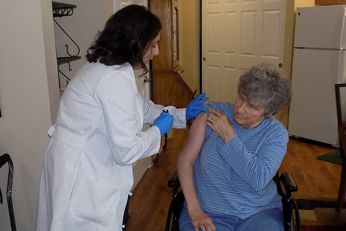 Jennifer Shannon, PharmD, administers pneumonia vaccine to patient MariJean Brown.