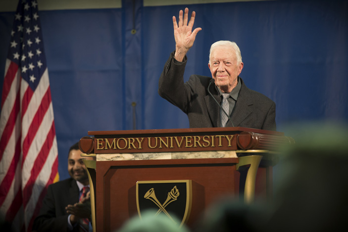 U.S. President Jimmy Carter, hand raised, takes the podium at the 35th Annual Carter Town Hall at Emory University