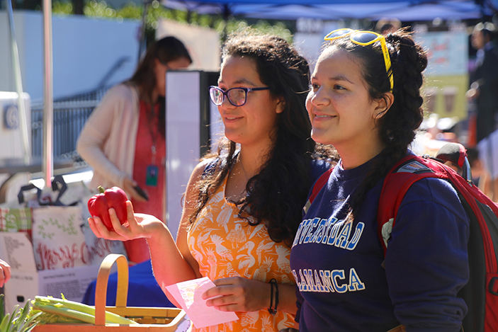 Students at produce booth of sustainable food fair