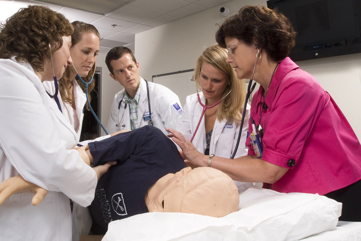 Medical students work on a simulation dummy
