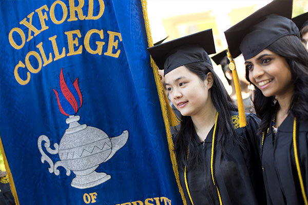 two students in cap and gown for commencement