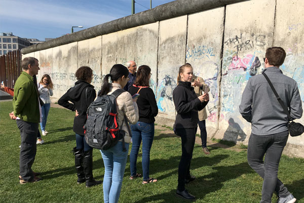 Students stand near the remnants of the Berlin Wall.