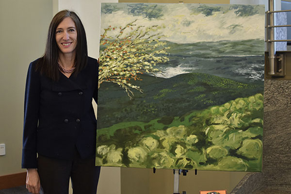 Catherine Chastain-Elliott, senior associate dean of academic affairs, with My Father Sees, her original oil painting.