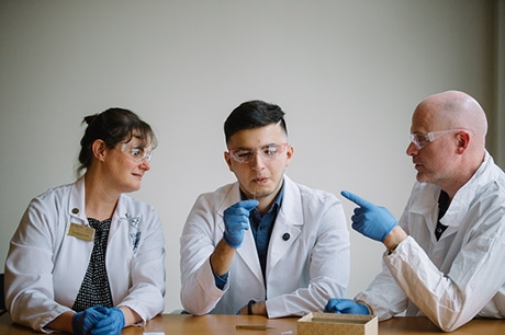 Emory College junior Kasey Cervantes (center) holds a tiny mosquito specimen like the hundreds he is helping catalog at the Natural History Museum in London. His summer research came about through a collaboration between Emory nursing professor Helen Baker (left) and CDC research entomologist Seth Irish (right). Emory Photo/Video