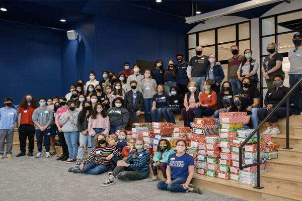 Emory Cares volunteers gather with gift boxes for children and teens in the Newton County Foster Care Program.