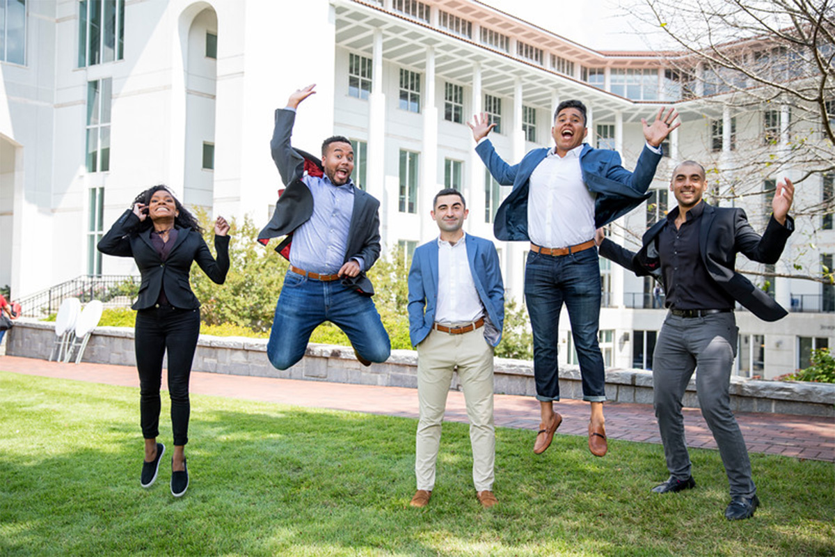 college students jumping in front of a building