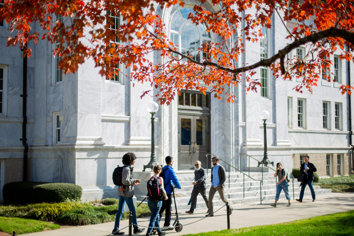 Students and others walking along sidewalk on the Quad.