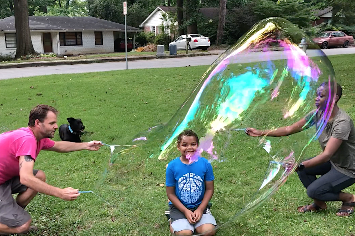 Justin, Jonah and Afeira outside with bubbles