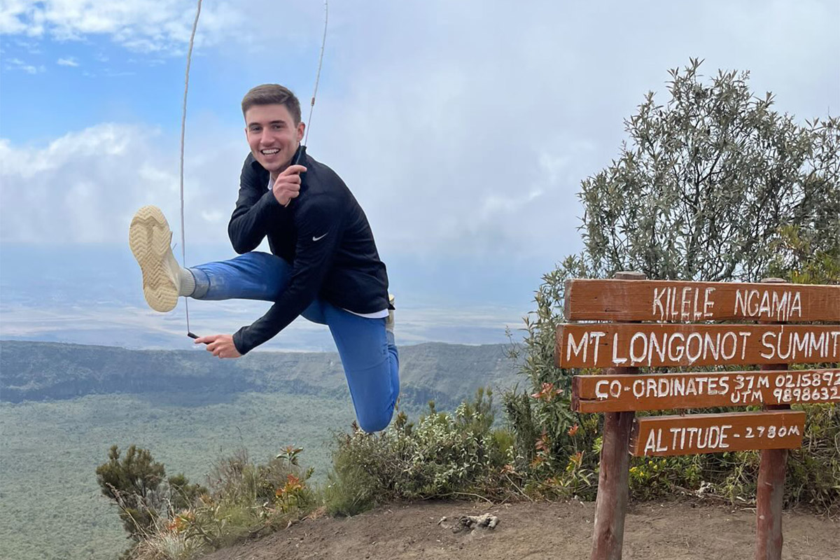 college age male jumping rope on top of a mountain