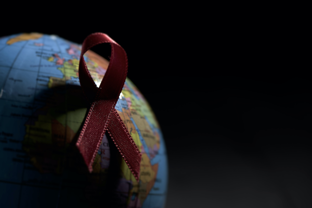 Globe with a red ribbon on black background