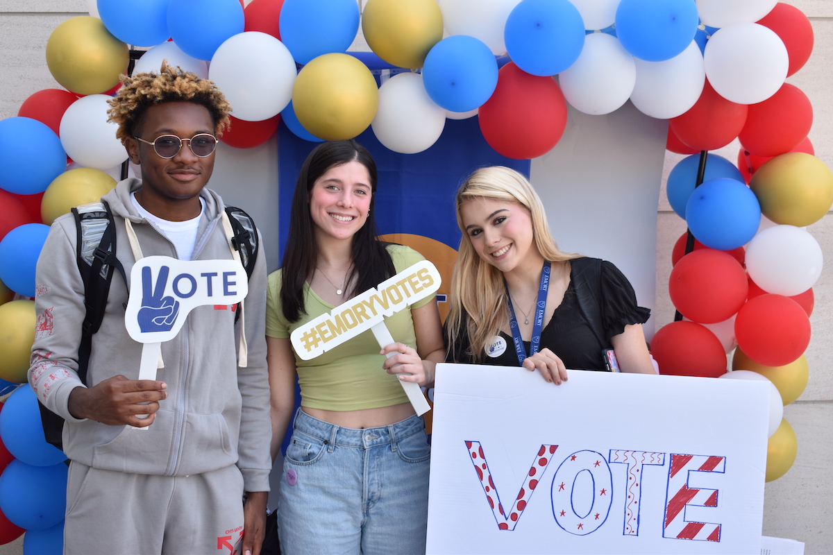 Students holding signs encouraging people to vote