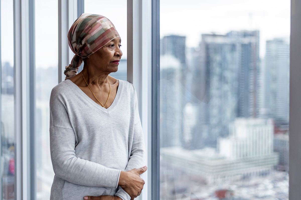 African-American cancer survivor gazing out a window.