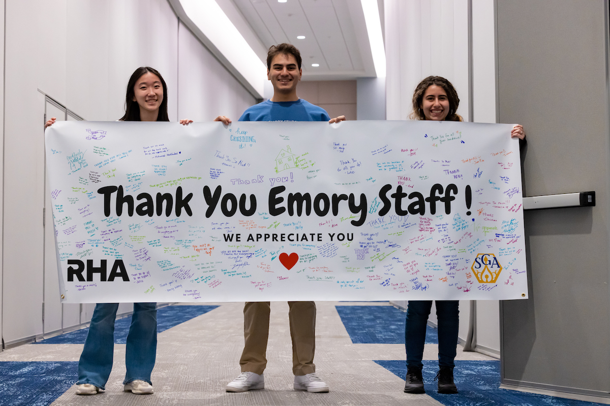 Photo: 3 students hold banner that reads ''Thank You Emory Staff!''
