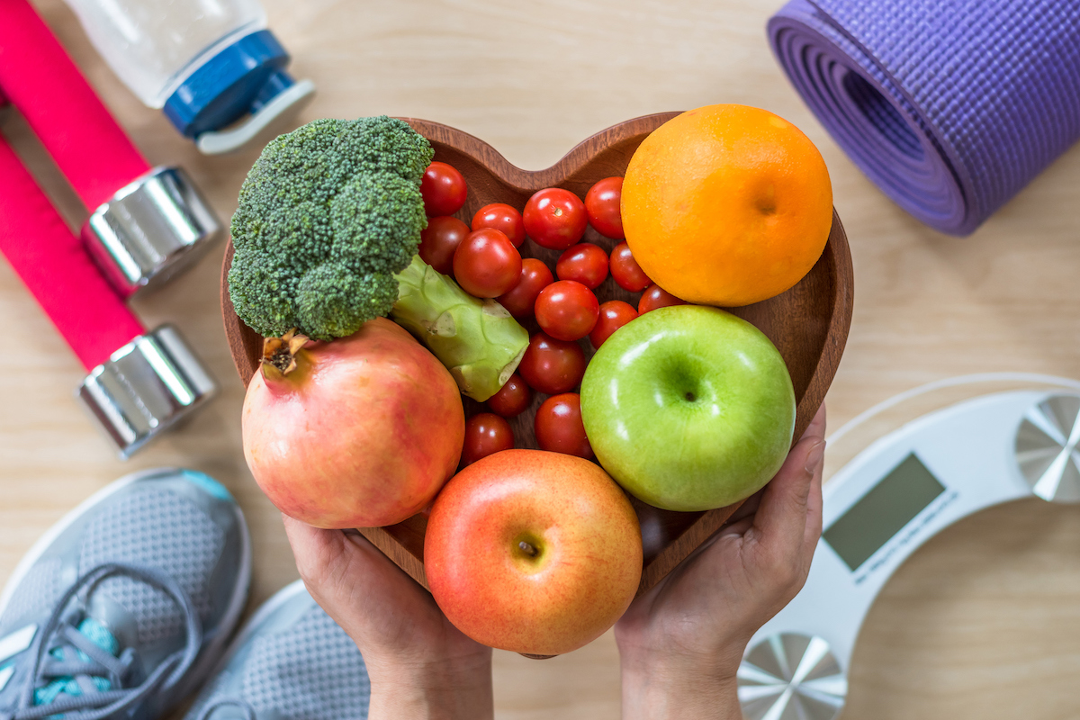 Photo: hands holding heart-shaped bowl filled with fruits and vegetables 