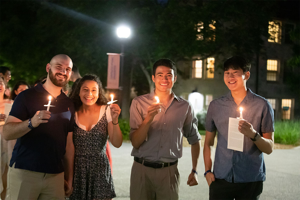 Students holding candles at night