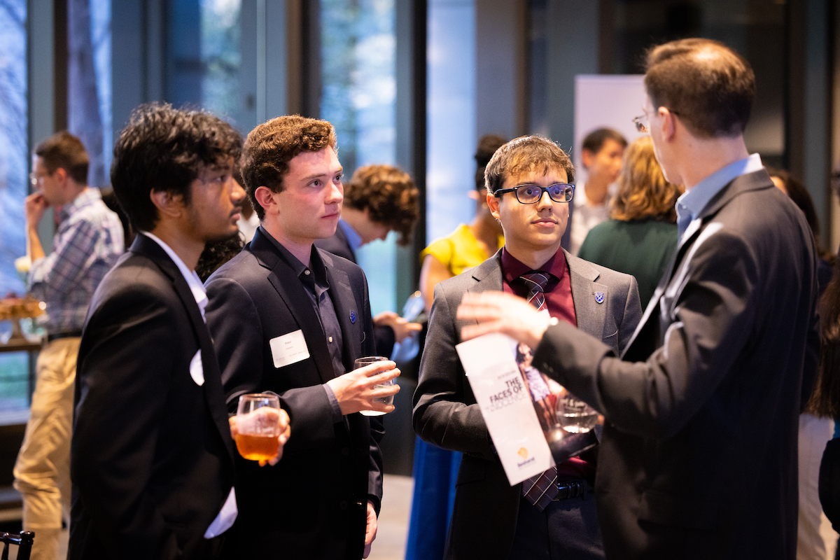 Photo of 3 students talking with Emory alum