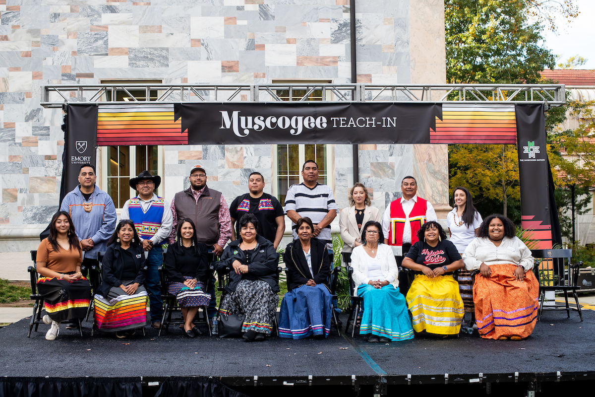 Photo: More than a dozen Muscogee Nation representatives seated and standing on stage during teach-in