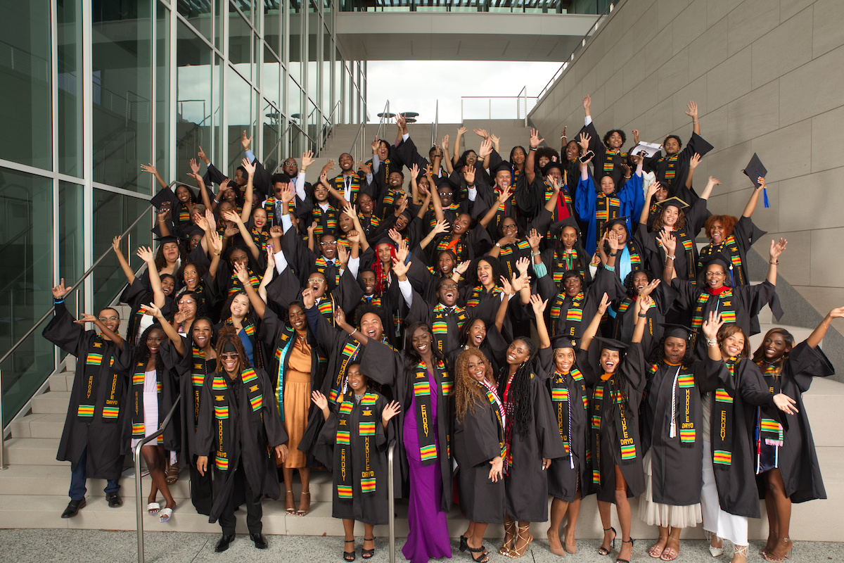 Group photo of dozens of students in graduation caps and gowns