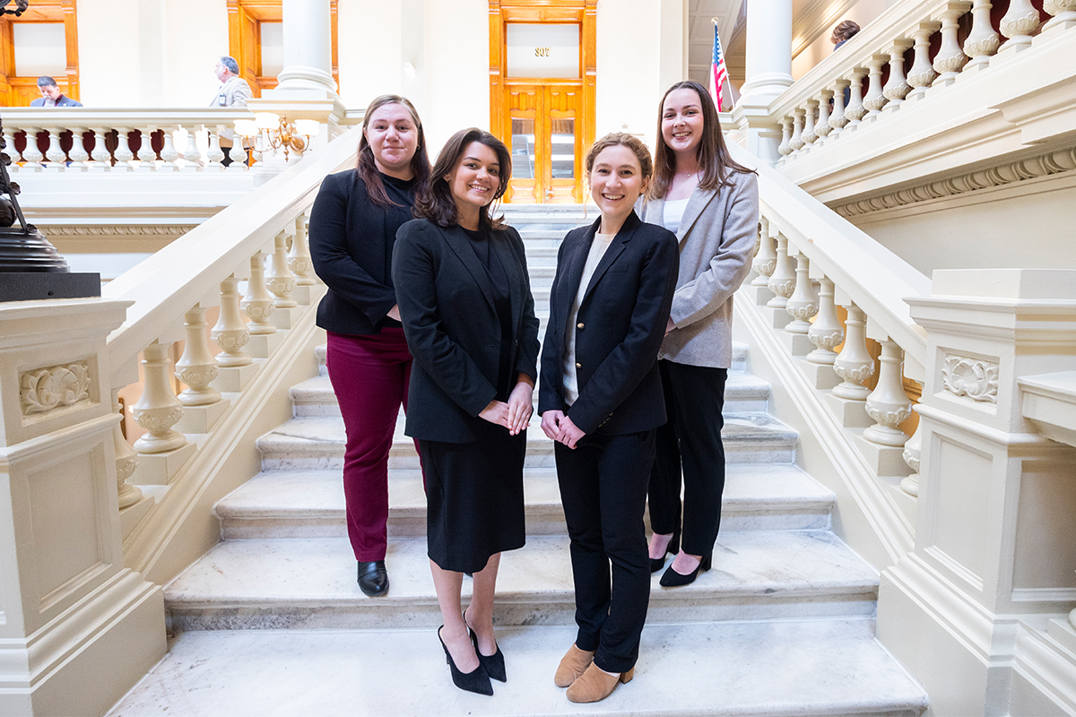 Photo of Sen. Parent and the three Emory student interns on a stairway in the state capitol