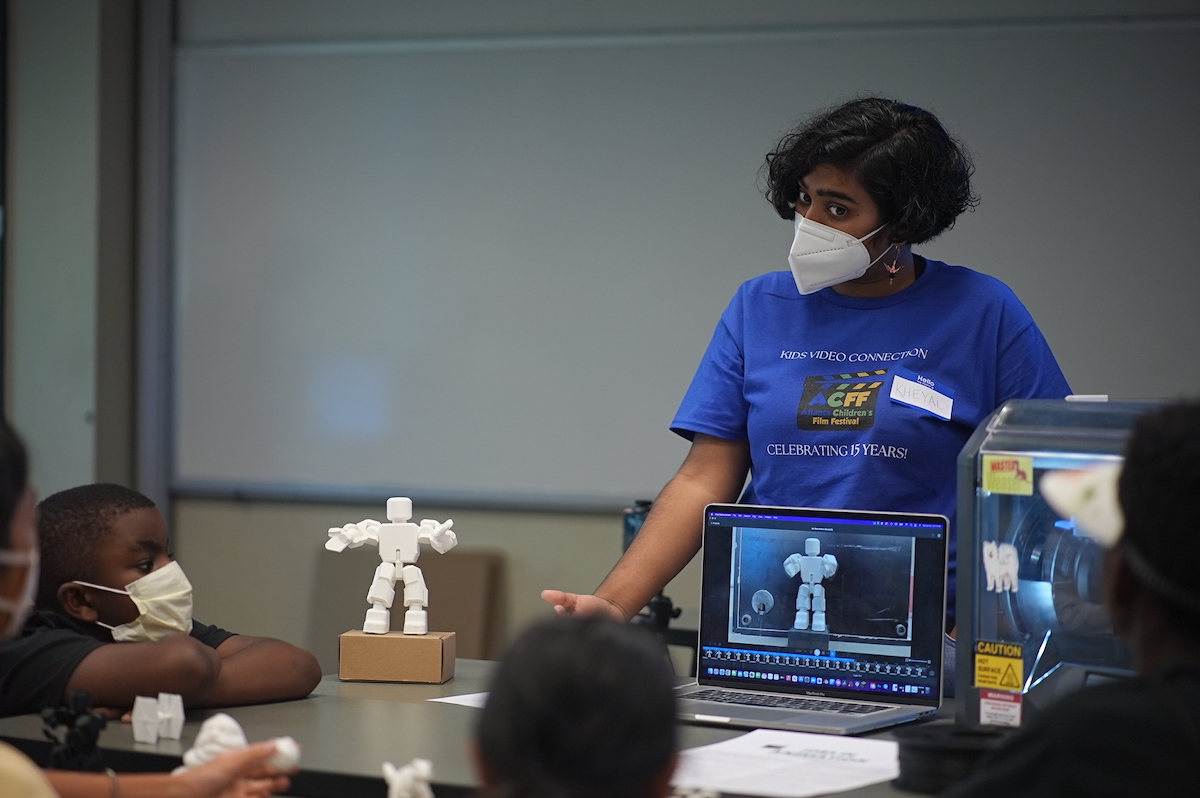 Photo: Adult and childrem discussing images on computer screen 